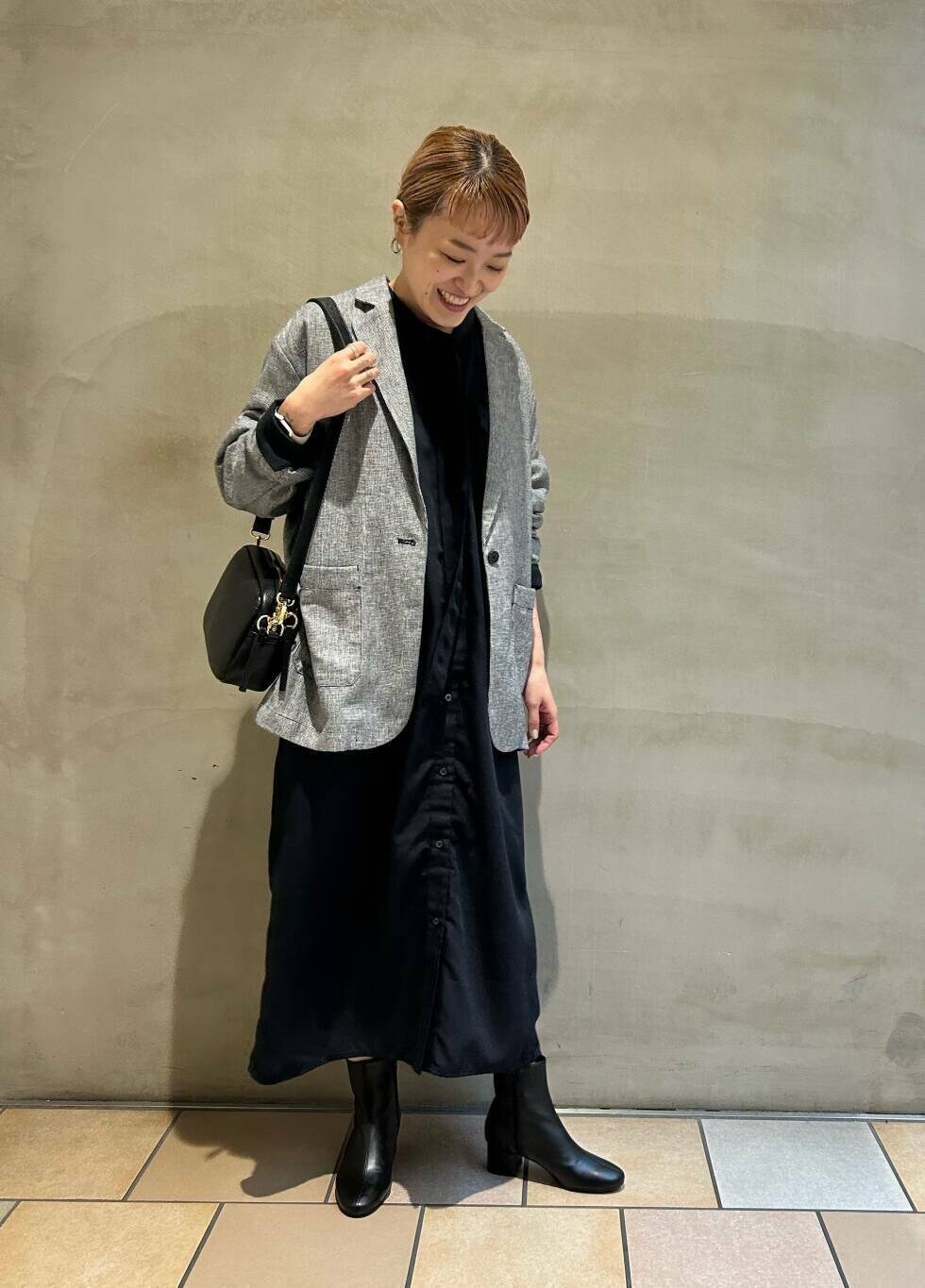 ブラック系のブーツ、ブラック系のショルダーバッグ、ブルー系のワンピースを着用したレディースの春コーディネートの3枚目の写真