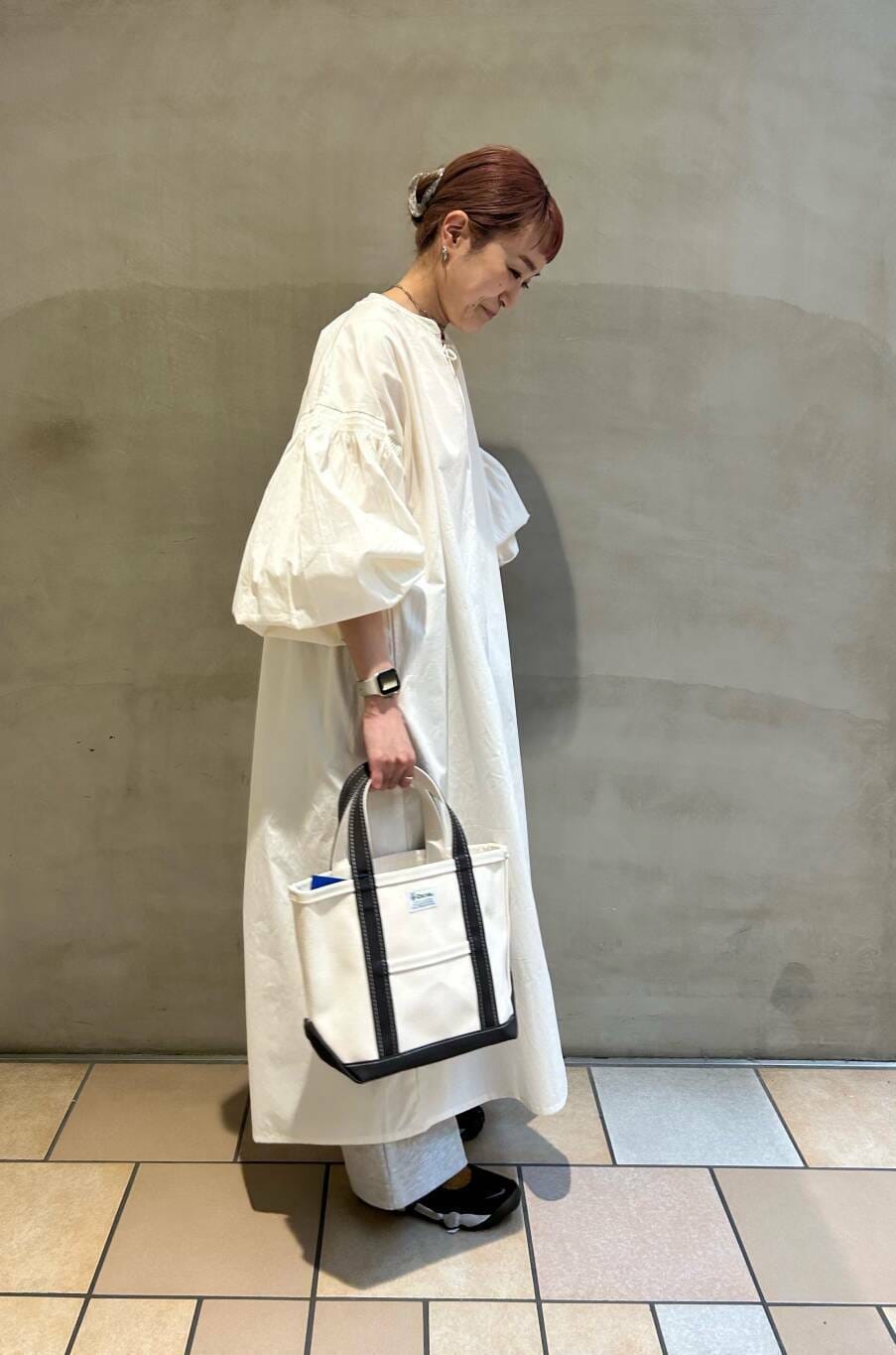 グレー系のその他パンツ、ピンク系のTシャツ/カットソー、ホワイト系のワンピースを着用したレディースの春コーディネートの2枚目の写真
