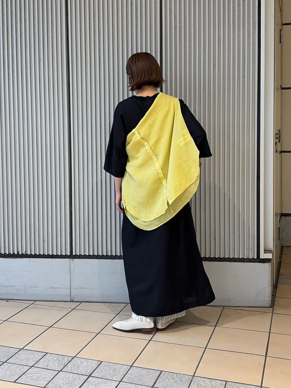 ブラック系のワンピース、イエロー系のシャツ/ブラウス、ベージュ系のその他パンツを着用したレディースの夏コーディネートの3枚目の写真