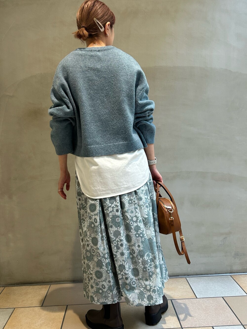 ホワイト系のTシャツ/カットソー、ブルー系のニット/セーター、ブラック系のスカートを着用したレディースの冬コーディネートの6枚目の写真