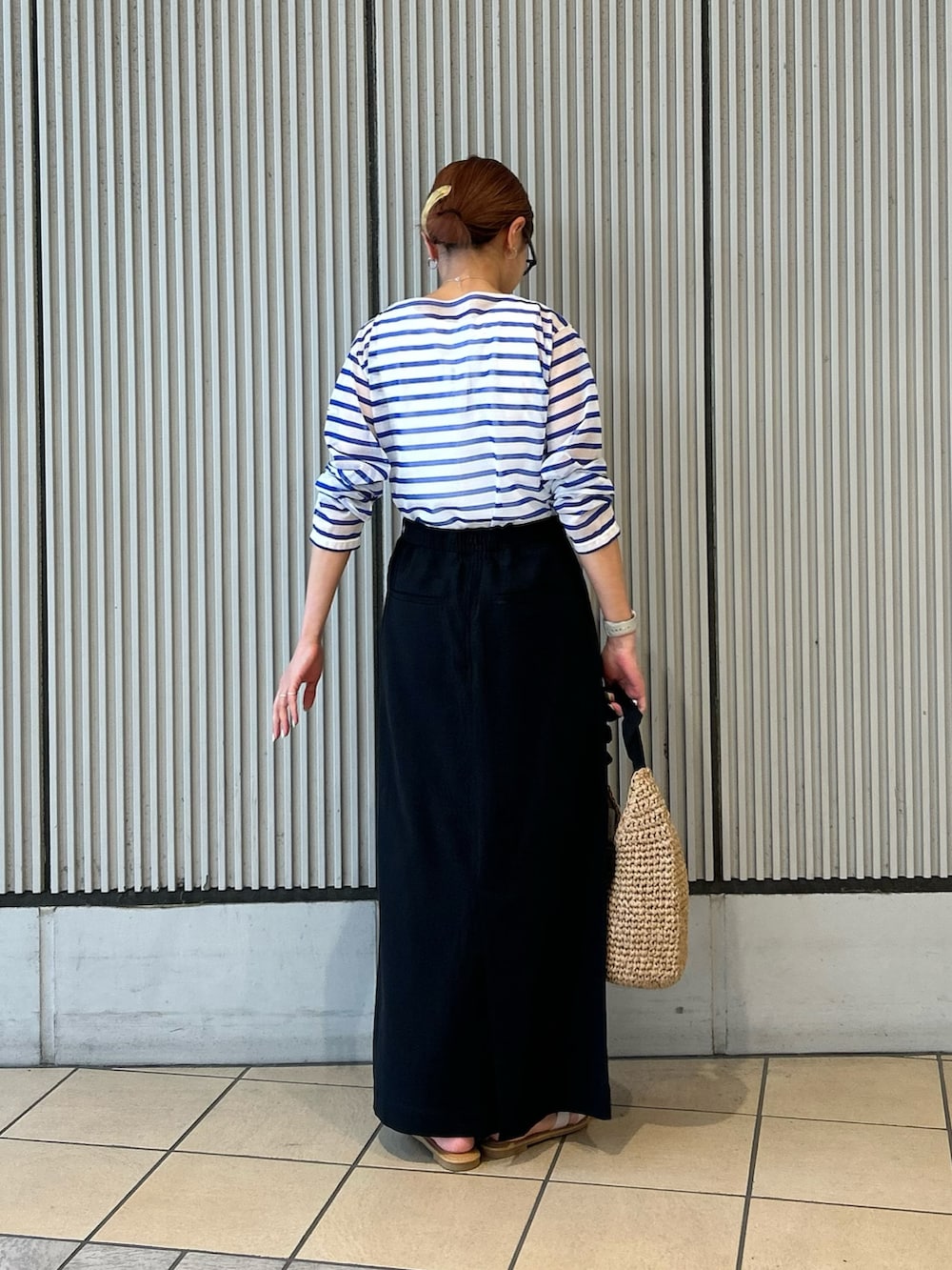ブルー系のTシャツ/カットソー、ブラック系のスカート、ホワイト系のサンダルを着用したレディースの夏コーディネートの3枚目の写真