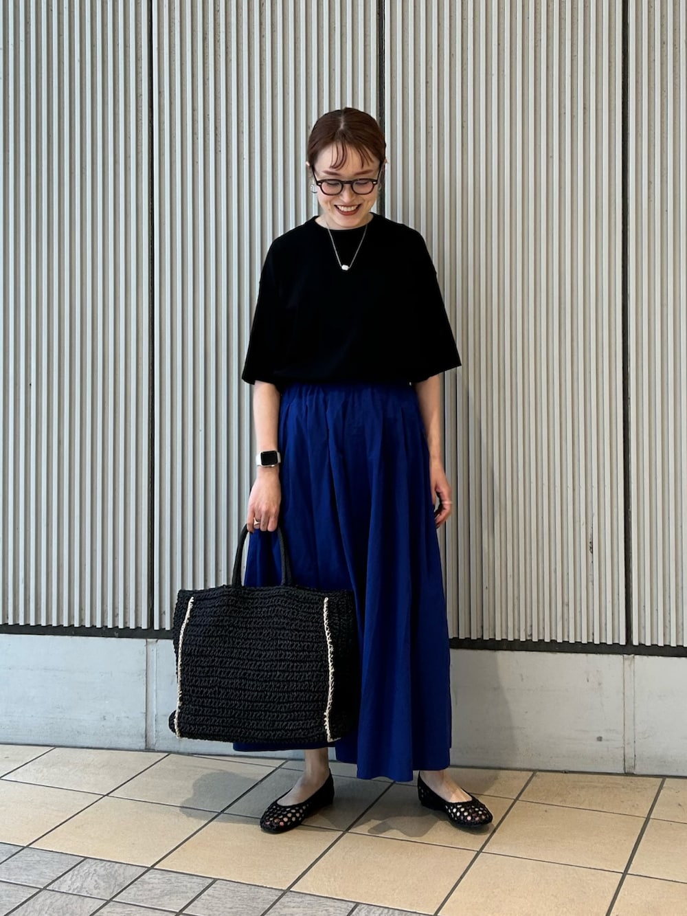ブラック系のTシャツ/カットソー、ブルー系のスカート、ブラック系のサンダルを着用したレディースの夏コーディネートの4枚目の写真