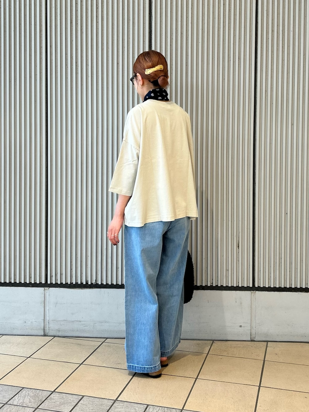 ブルー系のデニムパンツ、グレー系のTシャツ/カットソー、ブラック系のサンダルを着用したレディースの夏コーディネートの2枚目の写真