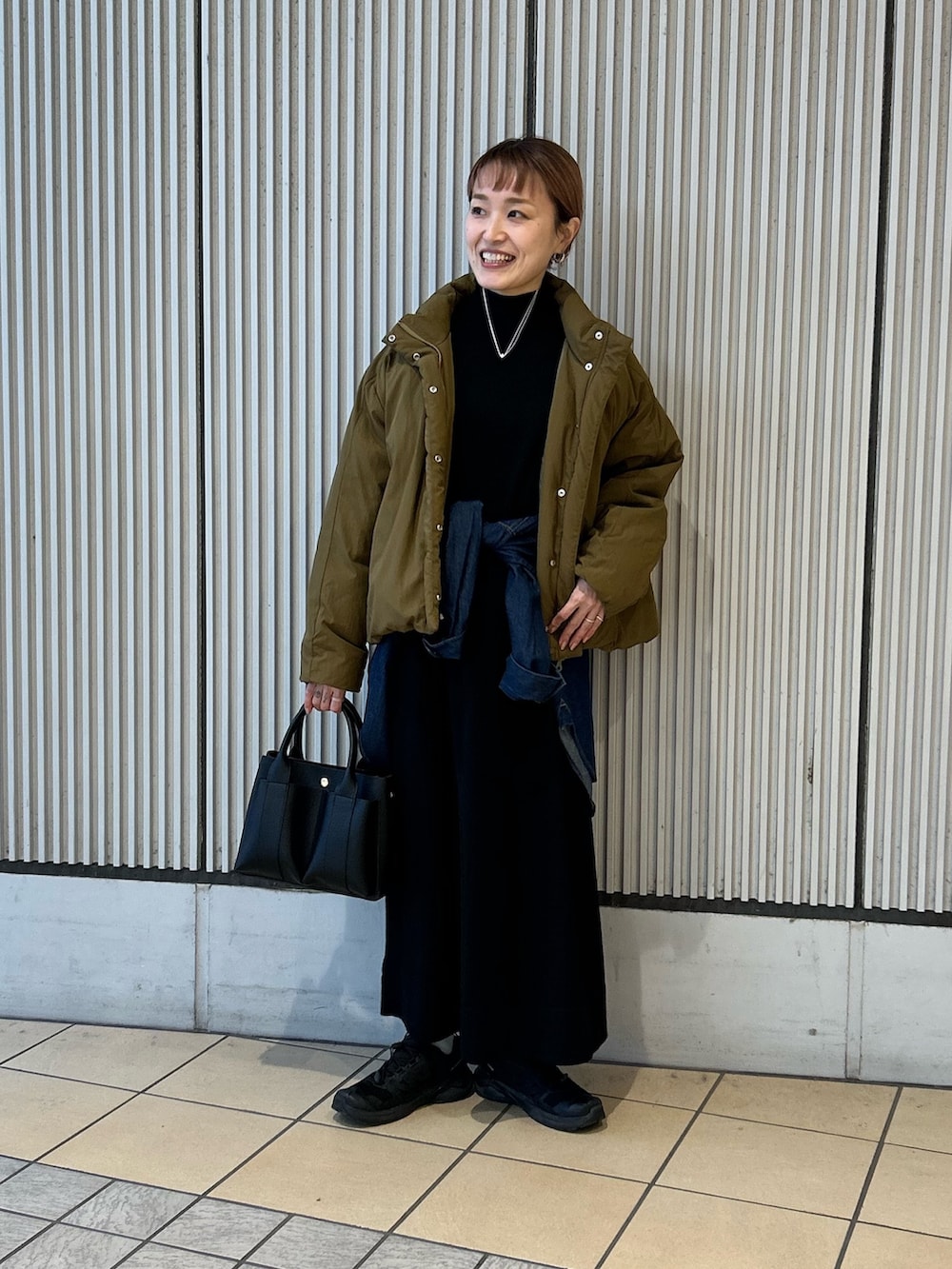 ブルー系のシャツ/ブラウス、ブラック系のトートバッグ、グリーン系のブルゾンを着用したレディースの冬コーディネートの3枚目の写真