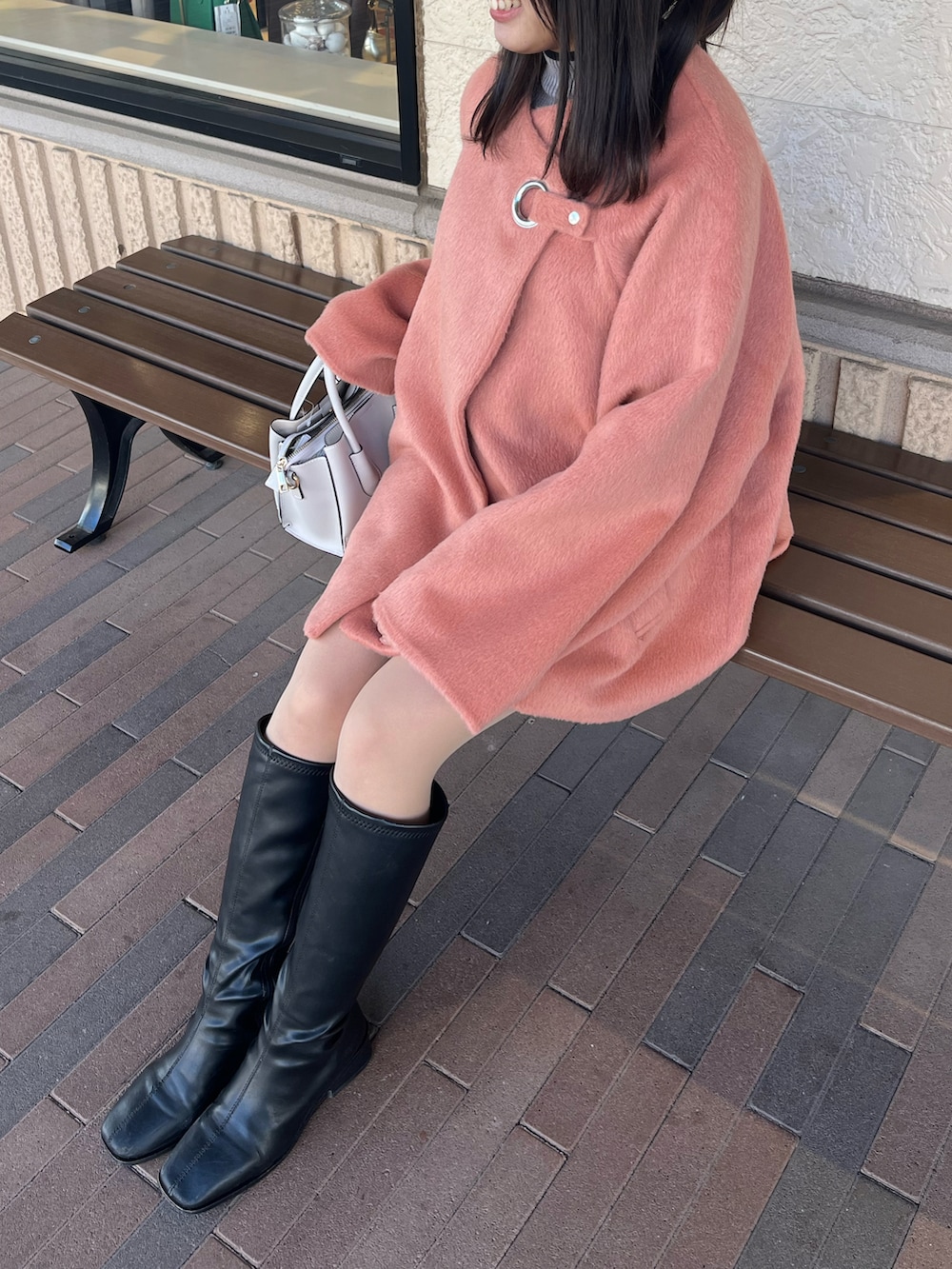 ピンク系のジャケット/アウター、ブラック系のブーツを着用したレディースの春コーディネートの3枚目の写真