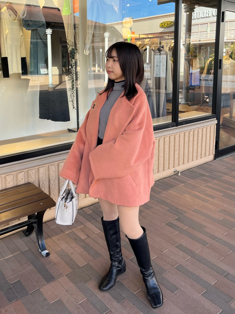 ピンク系のジャケット/アウター、ブラック系のブーツを着用したレディースの春コーディネートの2枚目の写真