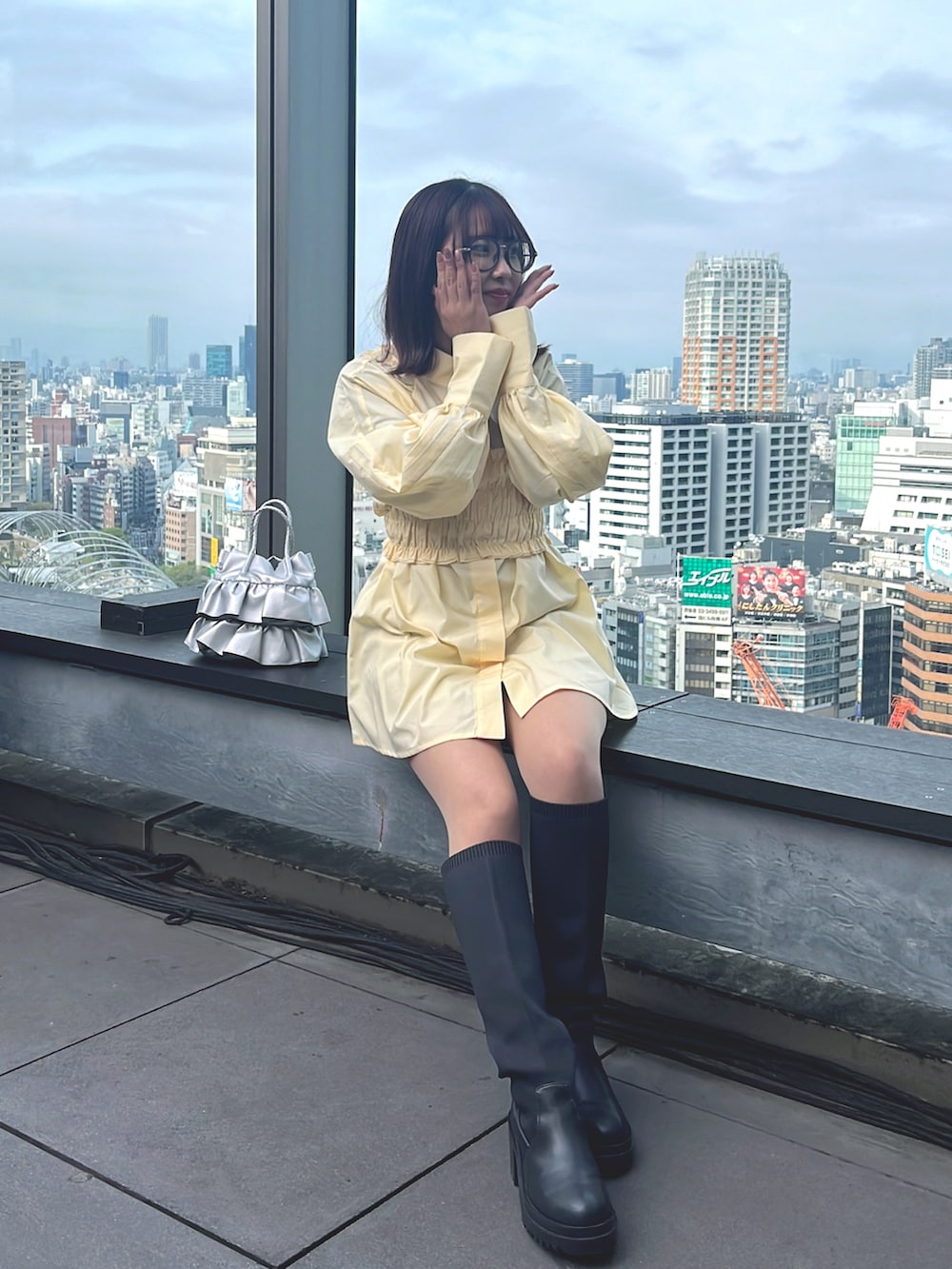 ブラック系のデニムジャケット、イエロー系のシャツ/ブラウス、シルバー系のショルダーバッグを着用したレディースの春コーディネートの3枚目の写真