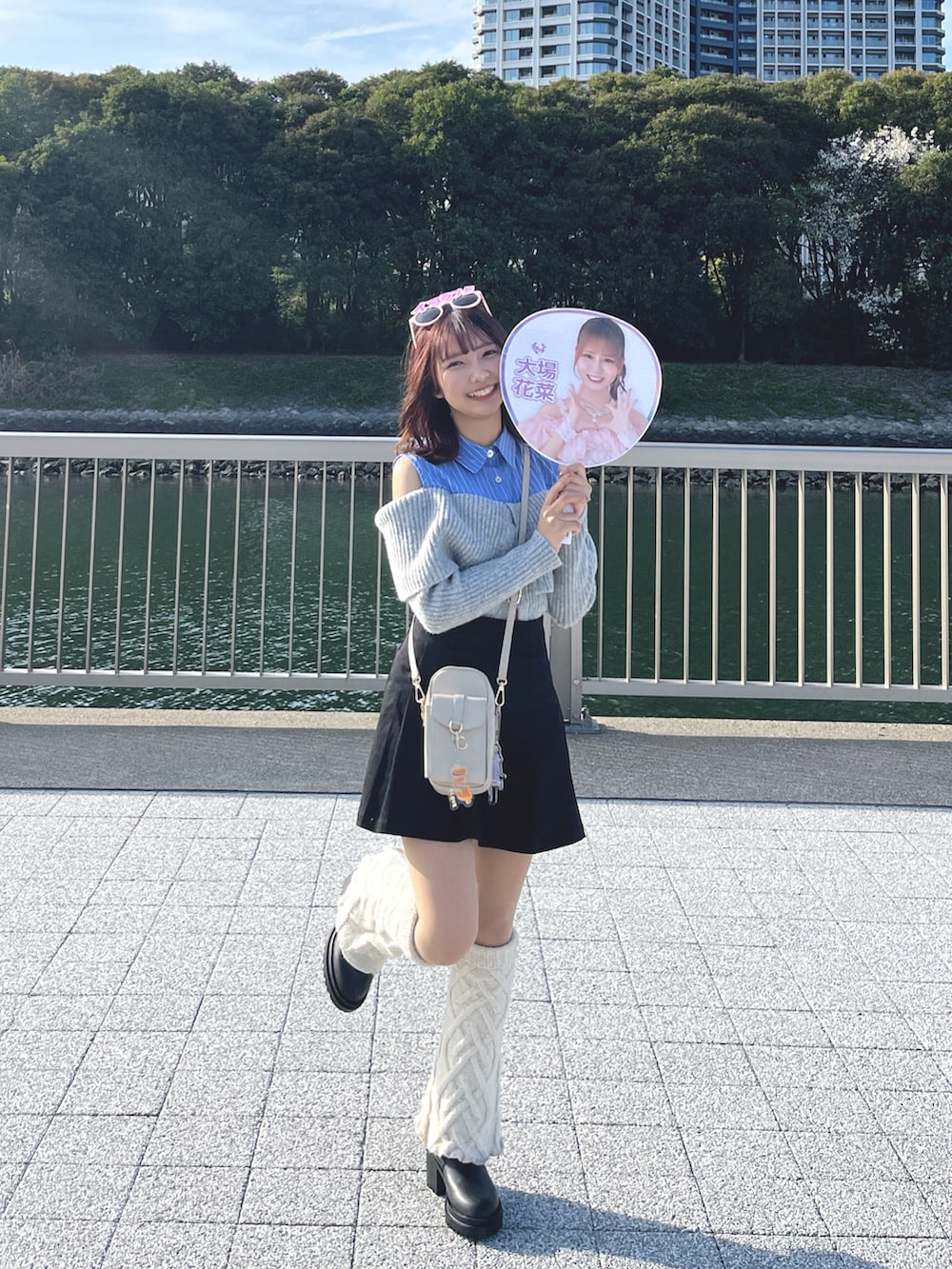 グレー系のトップス、ブラック系のスカート、ベージュ系のショルダーバッグを着用したレディースの春コーディネートの2枚目の写真