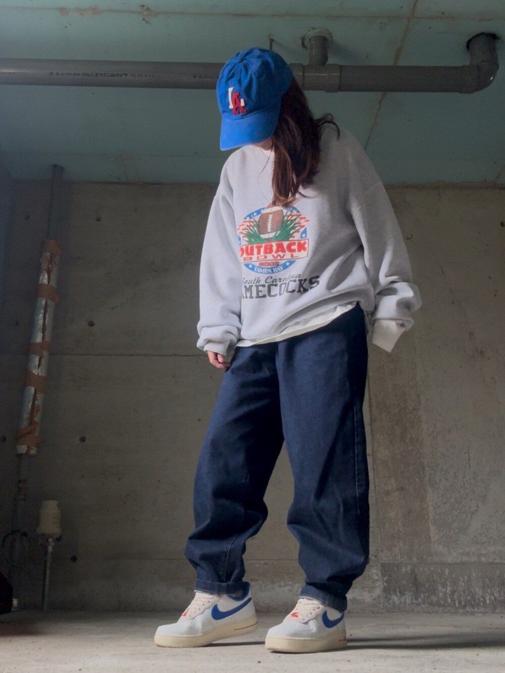 グレー系のスウェット、ホワイト系のスニーカー、ブルー系のデニムジャケットを着用したレディースの春コーディネートの2枚目の写真