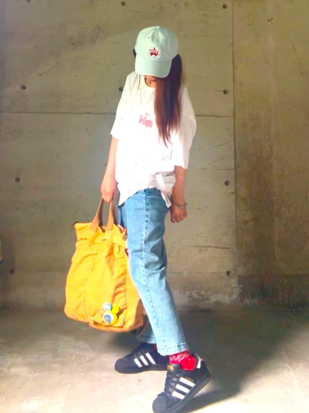 ブラック系のスニーカー、ホワイト系のTシャツ/カットソー、ブルー系のスカートを着用したレディースの夏コーディネートの3枚目の写真