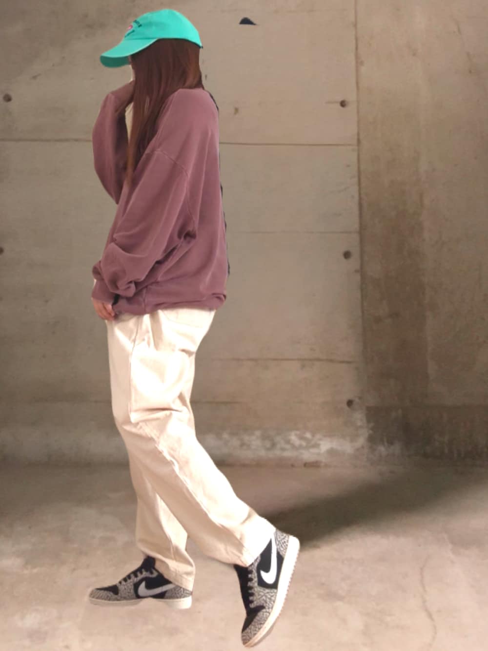 ホワイト系のパンツ、ブラック系のスニーカー、グリーン系のキャップを着用したレディースの春コーディネートの2枚目の写真