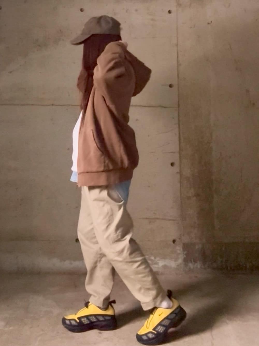 ホワイト系のTシャツ/カットソー、イエロー系のスニーカー、ブラウン系のキャップを着用したレディースの春コーディネートの2枚目の写真