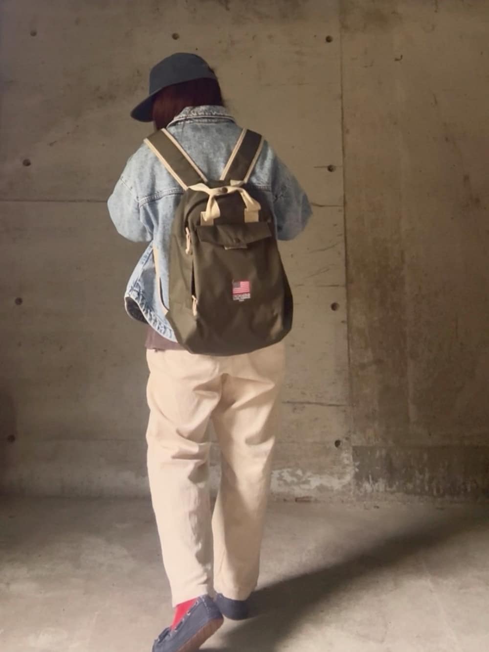 ブルー系のスウェット、ブルー系のデニムジャケット、グリーン系のバックパック/リュックを着用したレディースの秋コーディネートの3枚目の写真