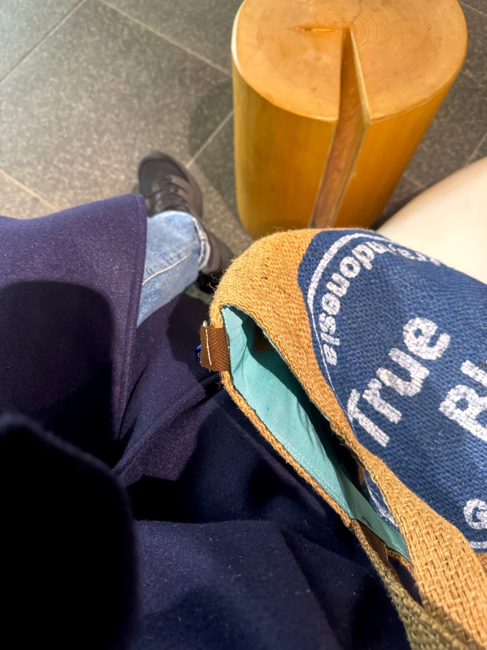 ブルー系のステンカラーコート、ブルー系のTシャツ/カットソー、ブラック系のスニーカーを着用したレディースの冬コーディネートの3枚目の写真