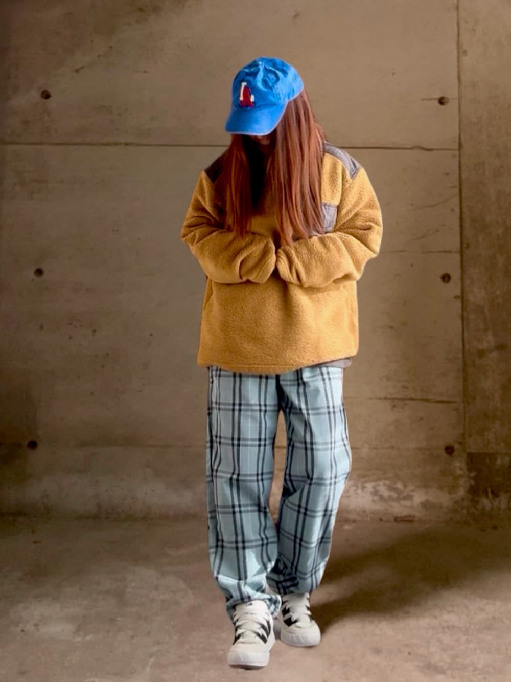 ベージュ系のジャケット/アウター、ホワイト系のスニーカー、ブルー系のキャップを着用したレディースの冬コーディネートの2枚目の写真