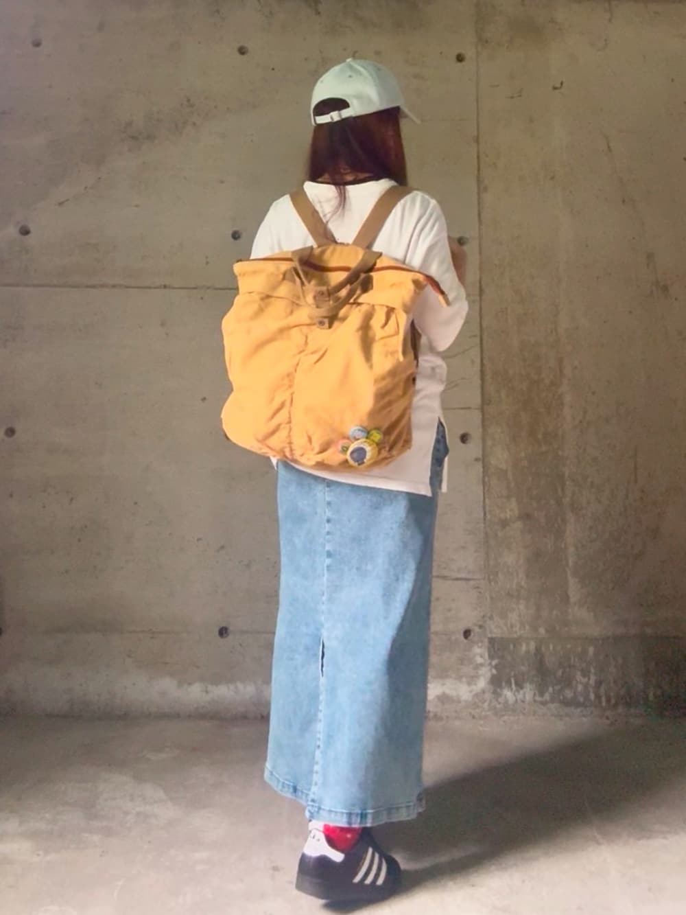 ブラック系のスニーカー、ホワイト系のTシャツ/カットソー、ブルー系のスカートを着用したレディースの夏コーディネートの4枚目の写真