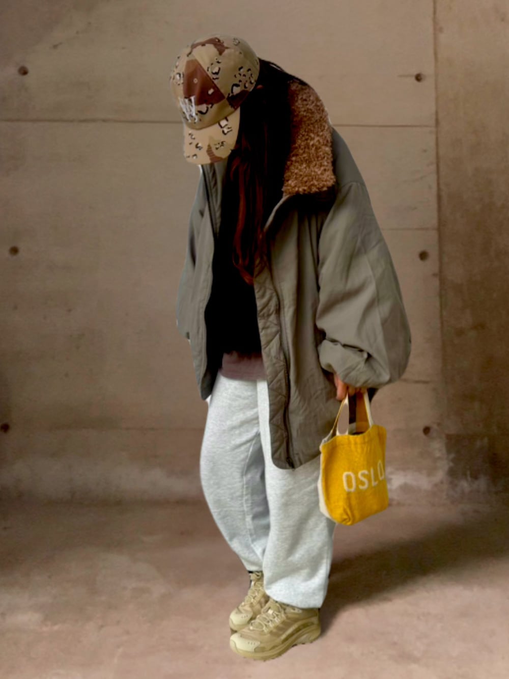 グレー系のスウェットパンツ、ブラック系のポロシャツ、グリーン系のジャケット/アウターを着用したレディースの冬コーディネートの2枚目の写真