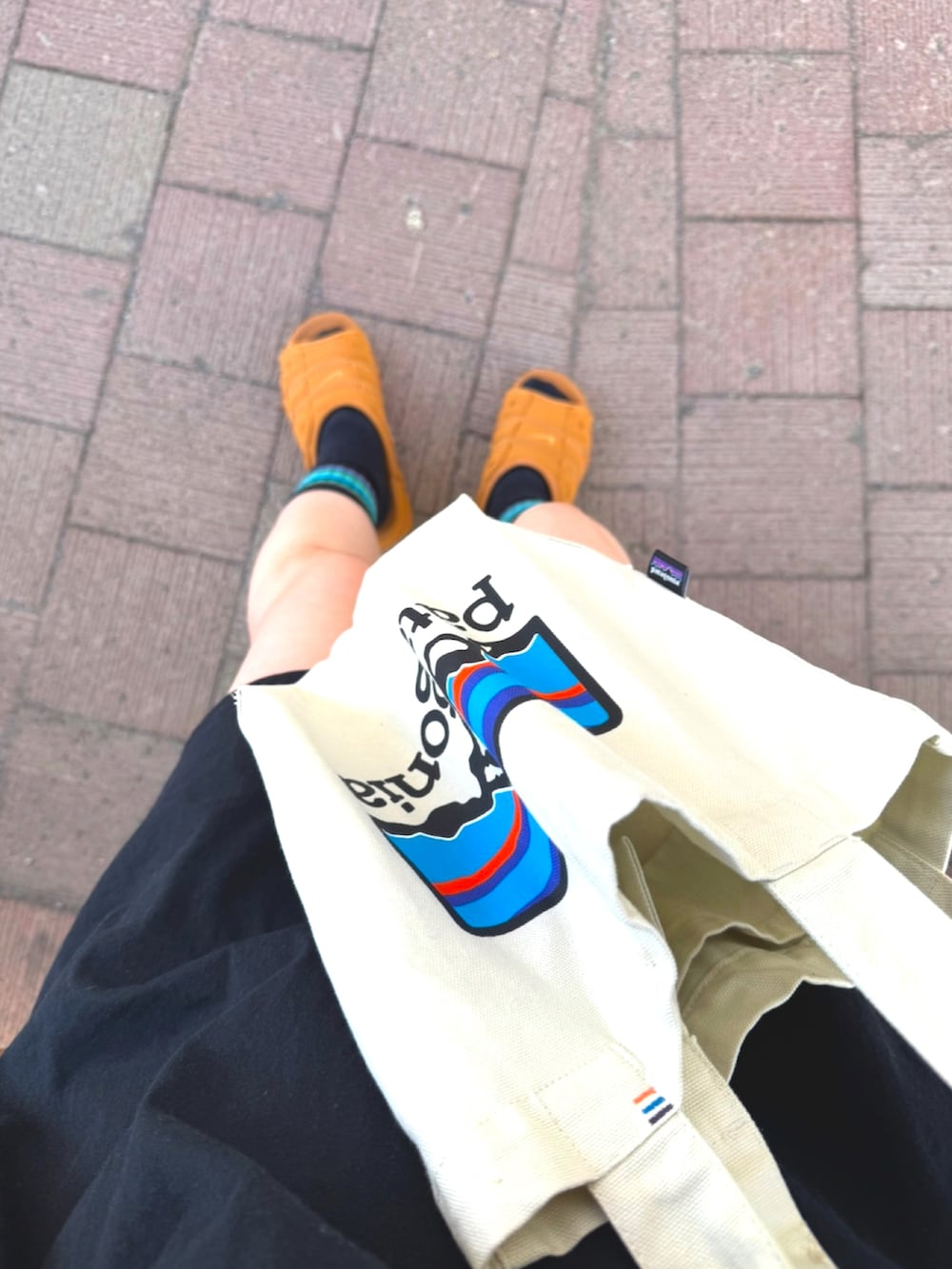 オレンジ系のその他パンツ、ホワイト系のトートバッグ、ブラウン系のサンダルを着用したレディースの夏コーディネートの2枚目の写真