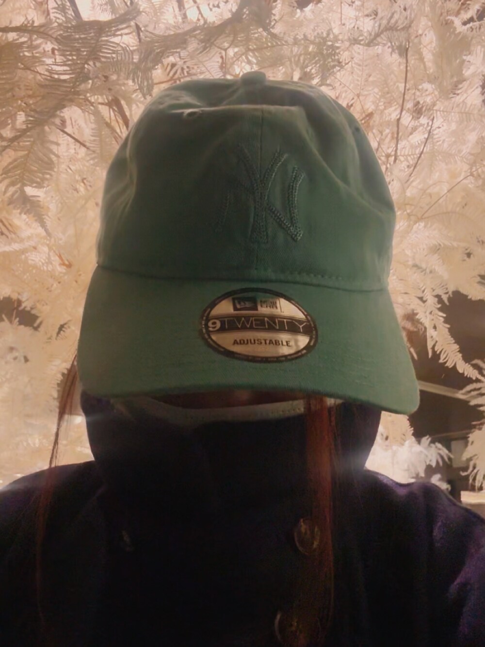 ブルー系のステンカラーコート、ブルー系のTシャツ/カットソー、ブラック系のスニーカーを着用したレディースの冬コーディネートの4枚目の写真