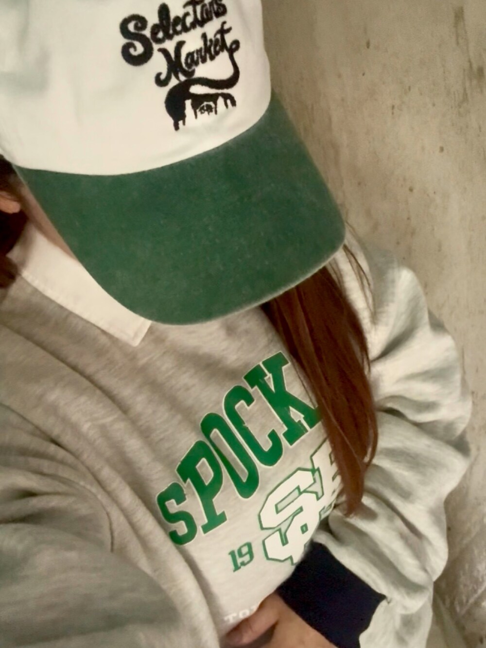 グレー系のスウェット、ブラック系のスニーカー、グリーン系のキャップを着用したレディースの秋コーディネートの4枚目の写真