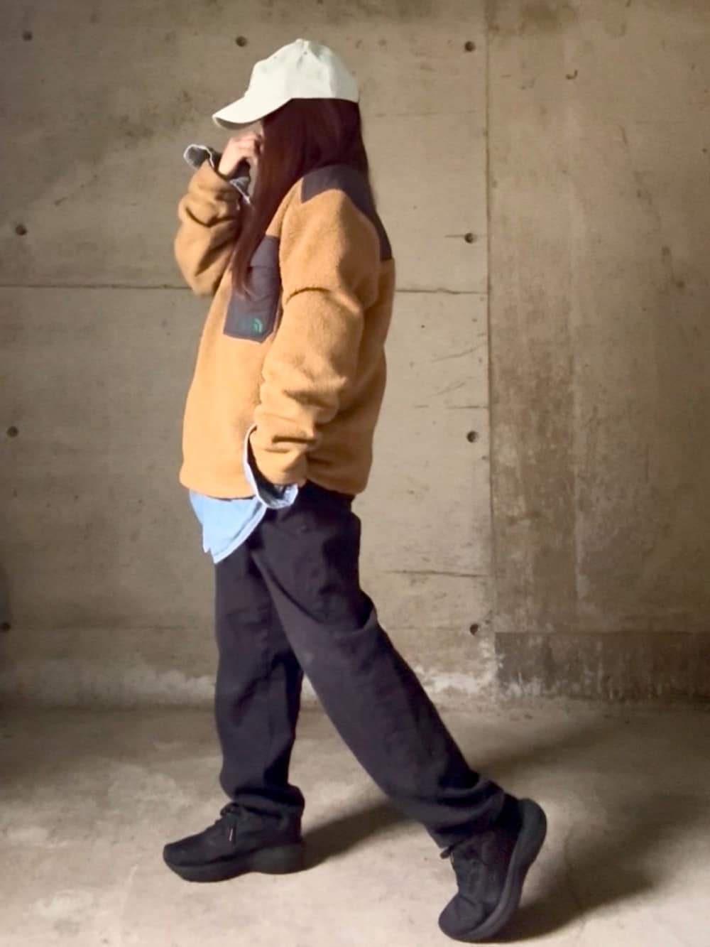 ベージュ系のジャケット/アウター、ブラック系のスニーカー、ブルー系のキャップを着用したレディースの冬コーディネートの2枚目の写真