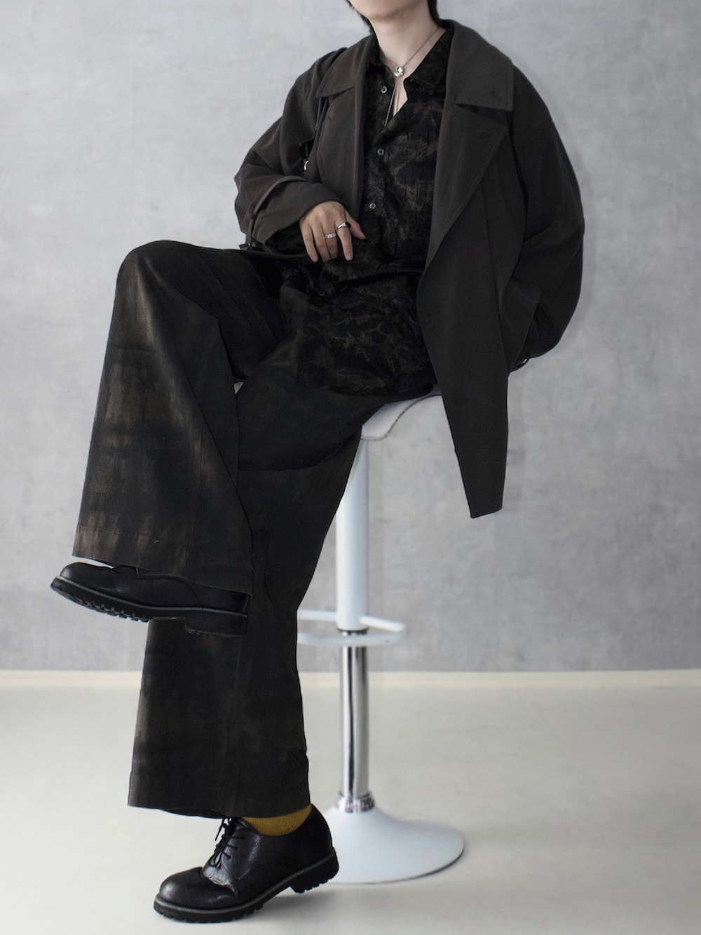 グリーン系のその他パンツ、ブラウン系のトレンチコート、ブラック系のシャツ/ブラウスを着用したメンズの秋コーディネートの2枚目の写真