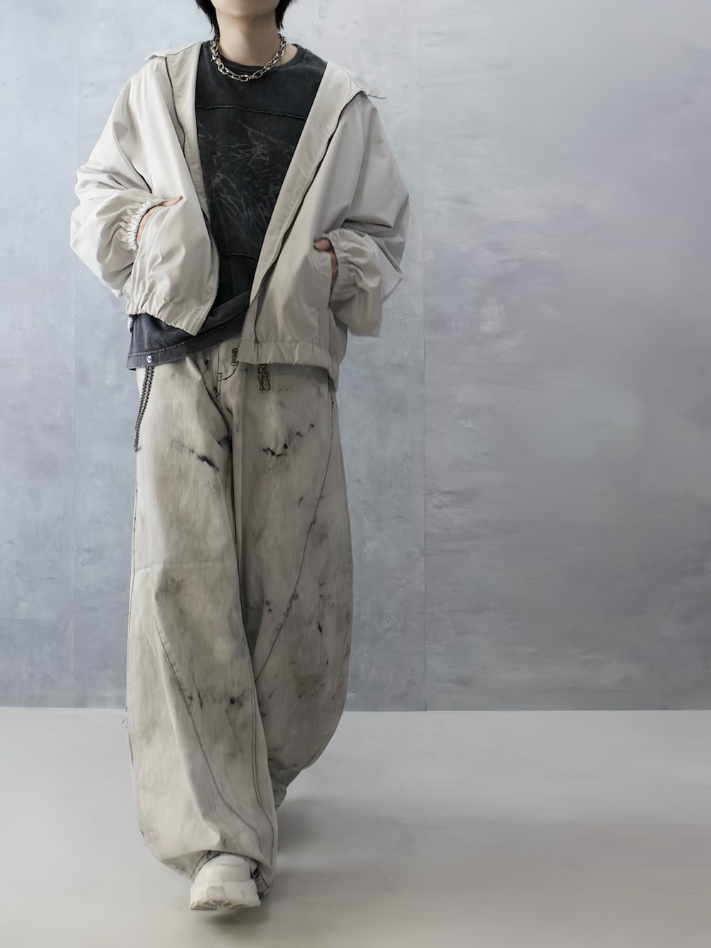 グレー系のデニムパンツ、ブラック系のTシャツ/カットソー、ホワイト系のブルゾンを着用したメンズの秋コーディネートの4枚目の写真