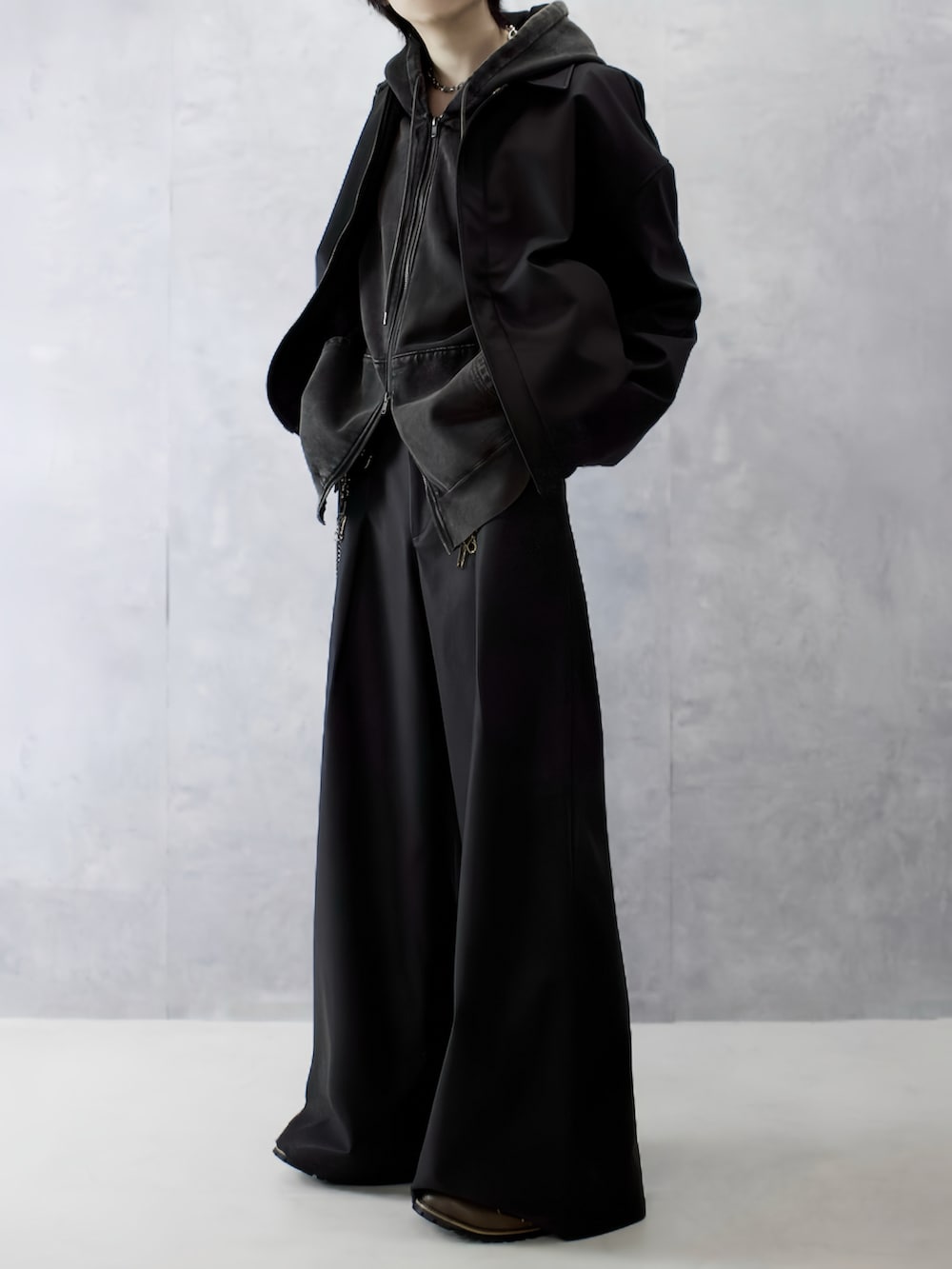 ブラウン系のパーカー、ブラック系のブーツ、ブラック系のブルゾンを着用したメンズの秋コーディネートの5枚目の写真