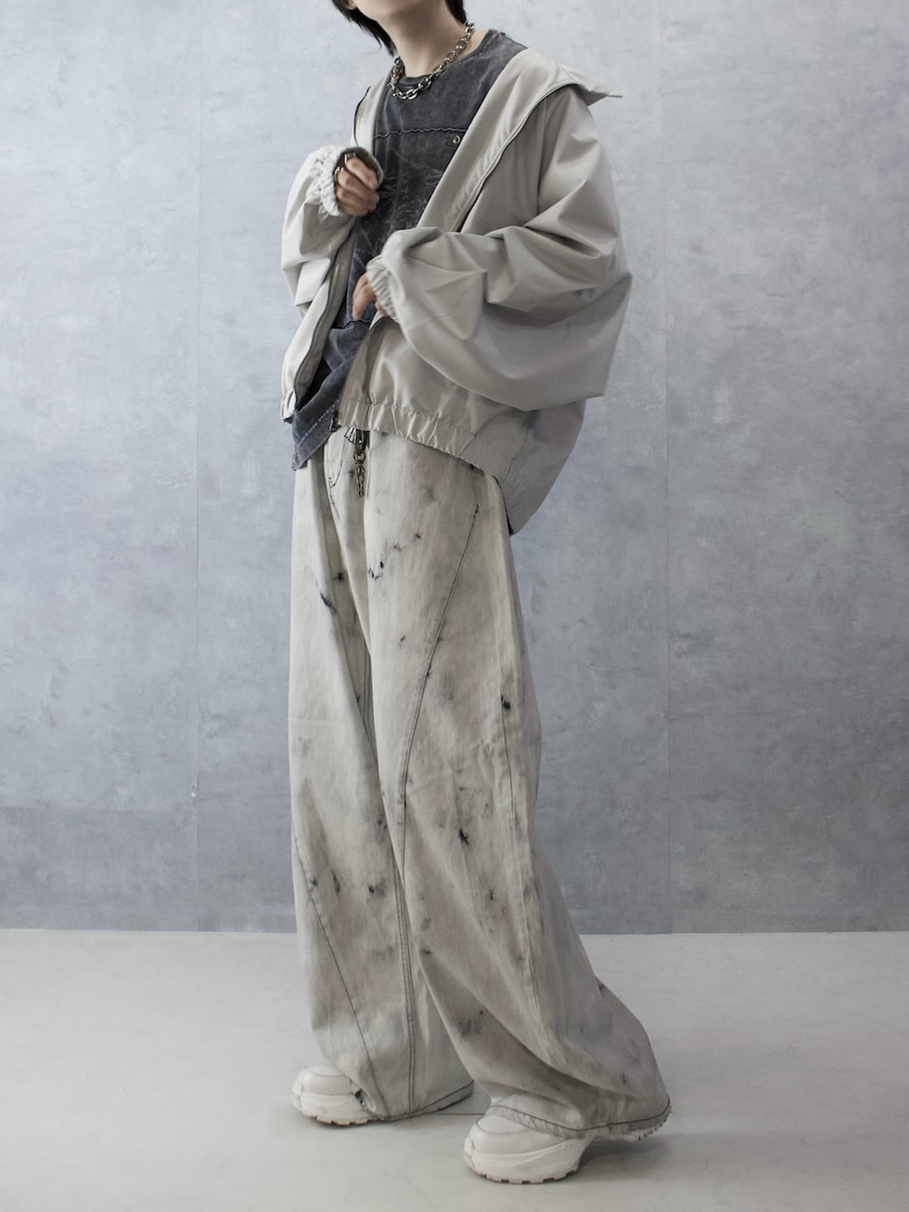 グレー系のデニムパンツ、ブラック系のTシャツ/カットソー、ホワイト系のブルゾンを着用したメンズの秋コーディネートの5枚目の写真