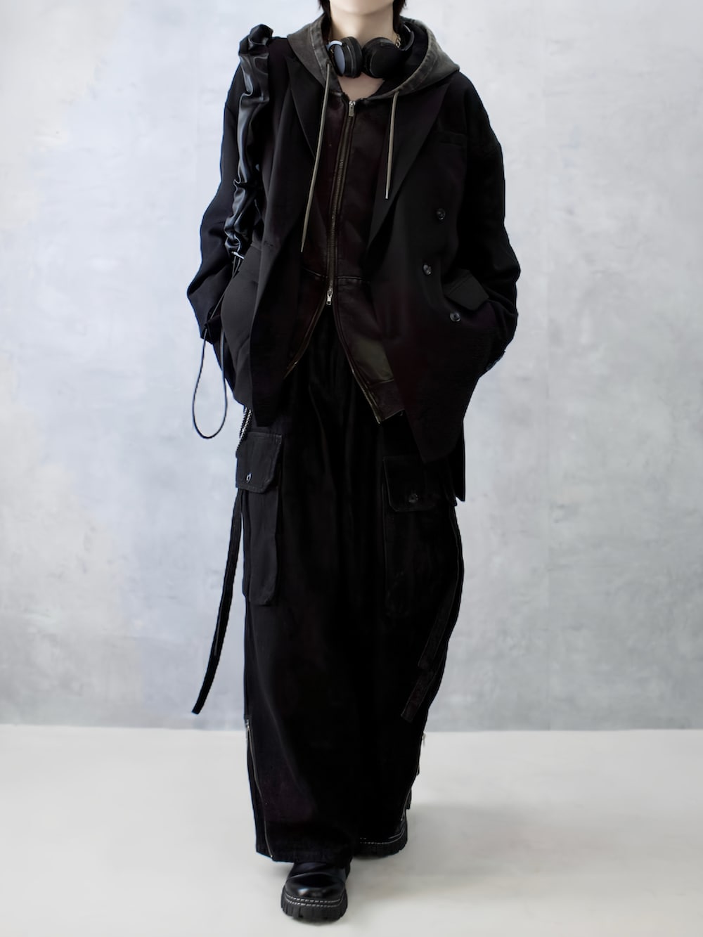 ブラック系のテーラードジャケット、ブラウン系のパーカー、ブラック系のカーゴパンツを着用したメンズの秋コーディネートの5枚目の写真