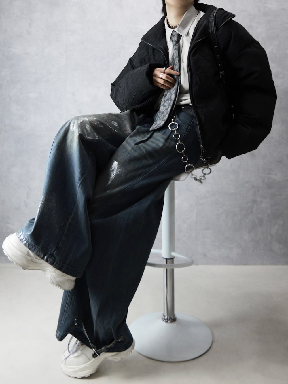 ブラック系のダウンジャケット/コート、ブラック系のショルダーバッグ、ホワイト系のスニーカーを着用したメンズの冬コーディネートの2枚目の写真