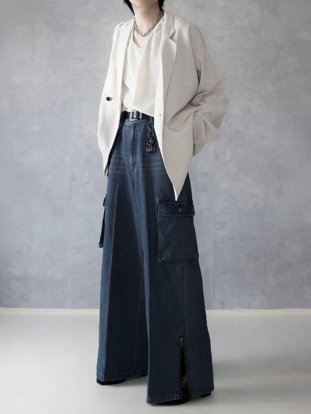 ブルー系のデニムパンツ、ホワイト系のタンクトップ、ホワイト系のテーラードジャケットを着用したメンズの秋コーディネートの5枚目の写真