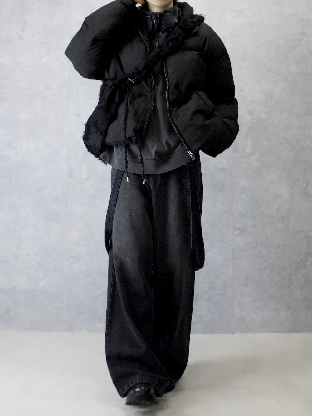 グレー系のデニムパンツ、ブラック系のスニーカー、ブラック系のダウンジャケット/コートを着用したメンズの冬コーディネートの4枚目の写真