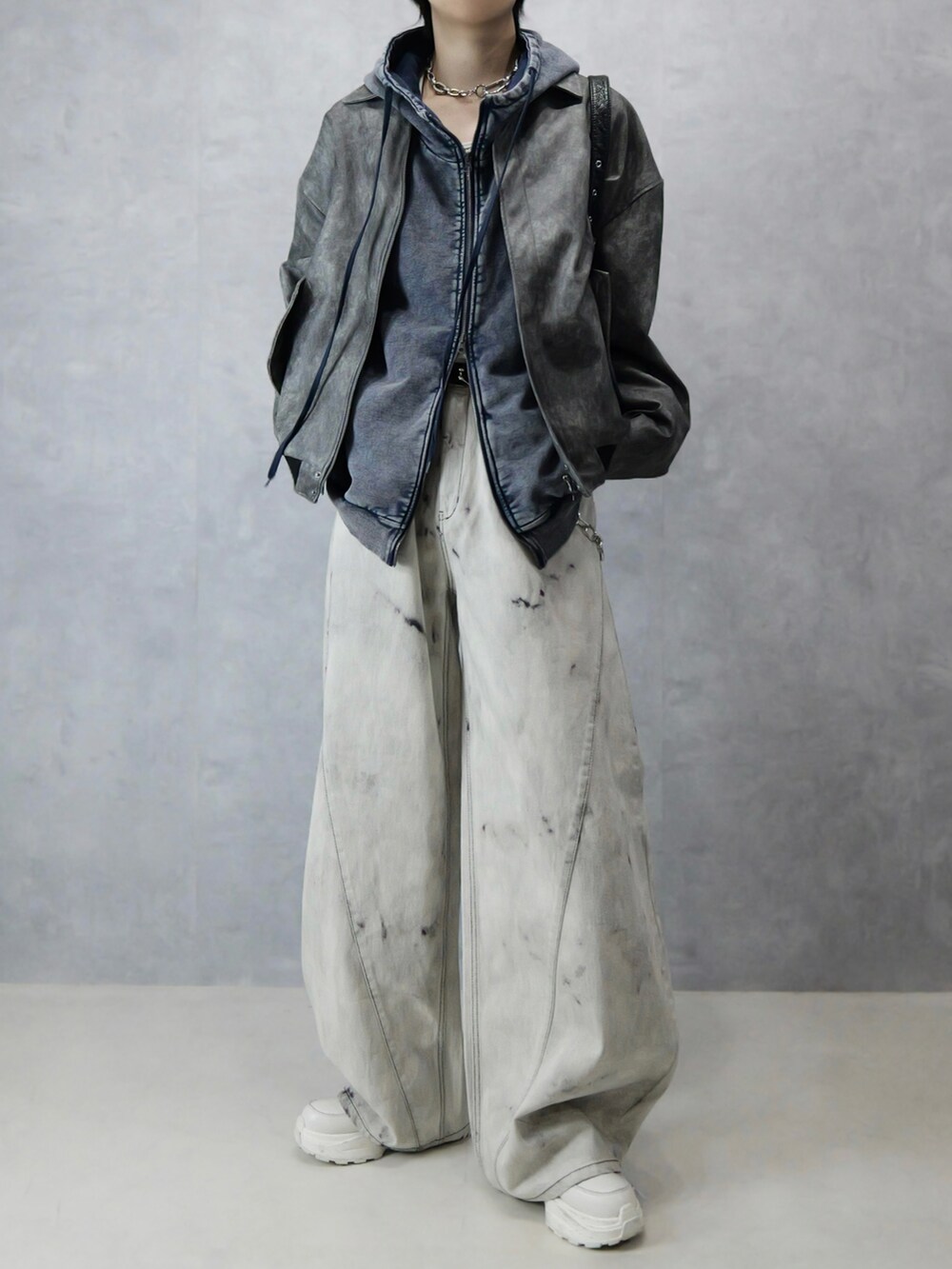 グレー系のデニムパンツ、ホワイト系のタンクトップ、ブラック系のショルダーバッグを着用したメンズの冬コーディネートの5枚目の写真