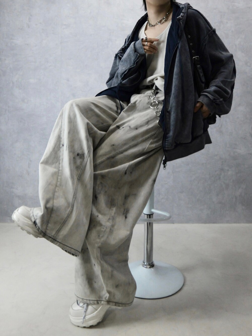 グレー系のデニムパンツ、ホワイト系のタンクトップ、ブラック系のショルダーバッグを着用したメンズの冬コーディネートの2枚目の写真