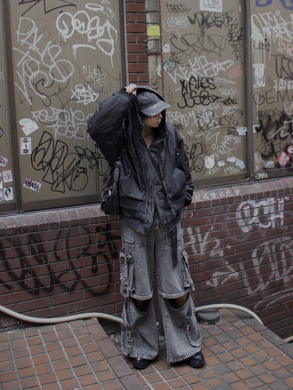 グレー系のデニムパンツ、ブラック系のスニーカー、ブラック系のMA-1を着用したメンズの冬コーディネートの4枚目の写真