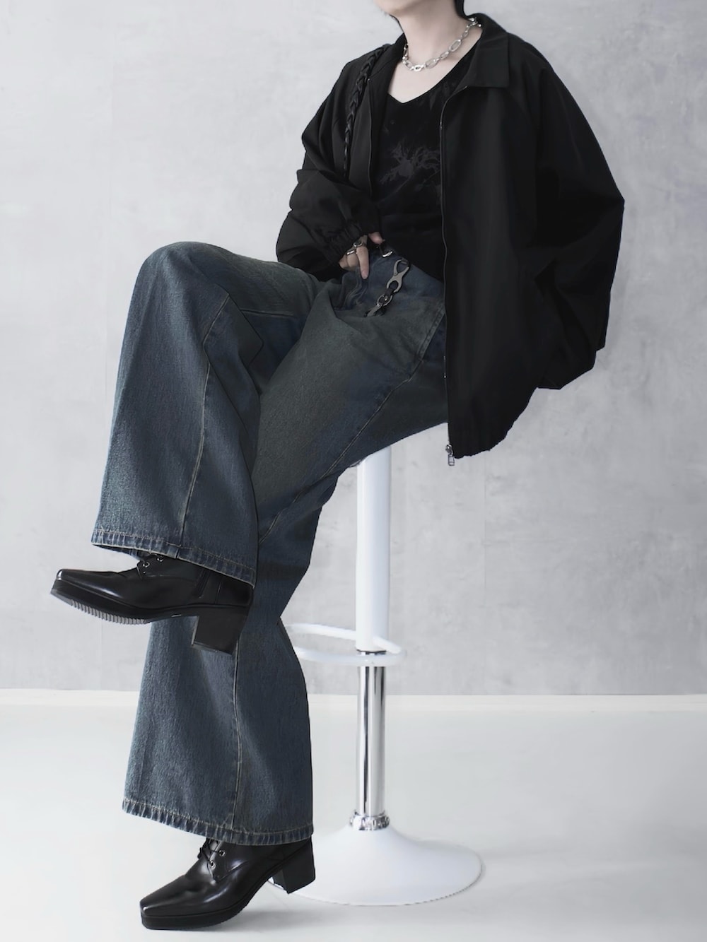 ブルー系のデニムパンツ、ブラック系のTシャツ/カットソー、ブラック系のブルゾンを着用したメンズの秋コーディネートの2枚目の写真