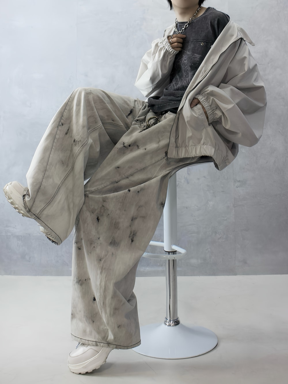 グレー系のデニムパンツ、ブラック系のTシャツ/カットソー、ホワイト系のブルゾンを着用したメンズの秋コーディネートの2枚目の写真