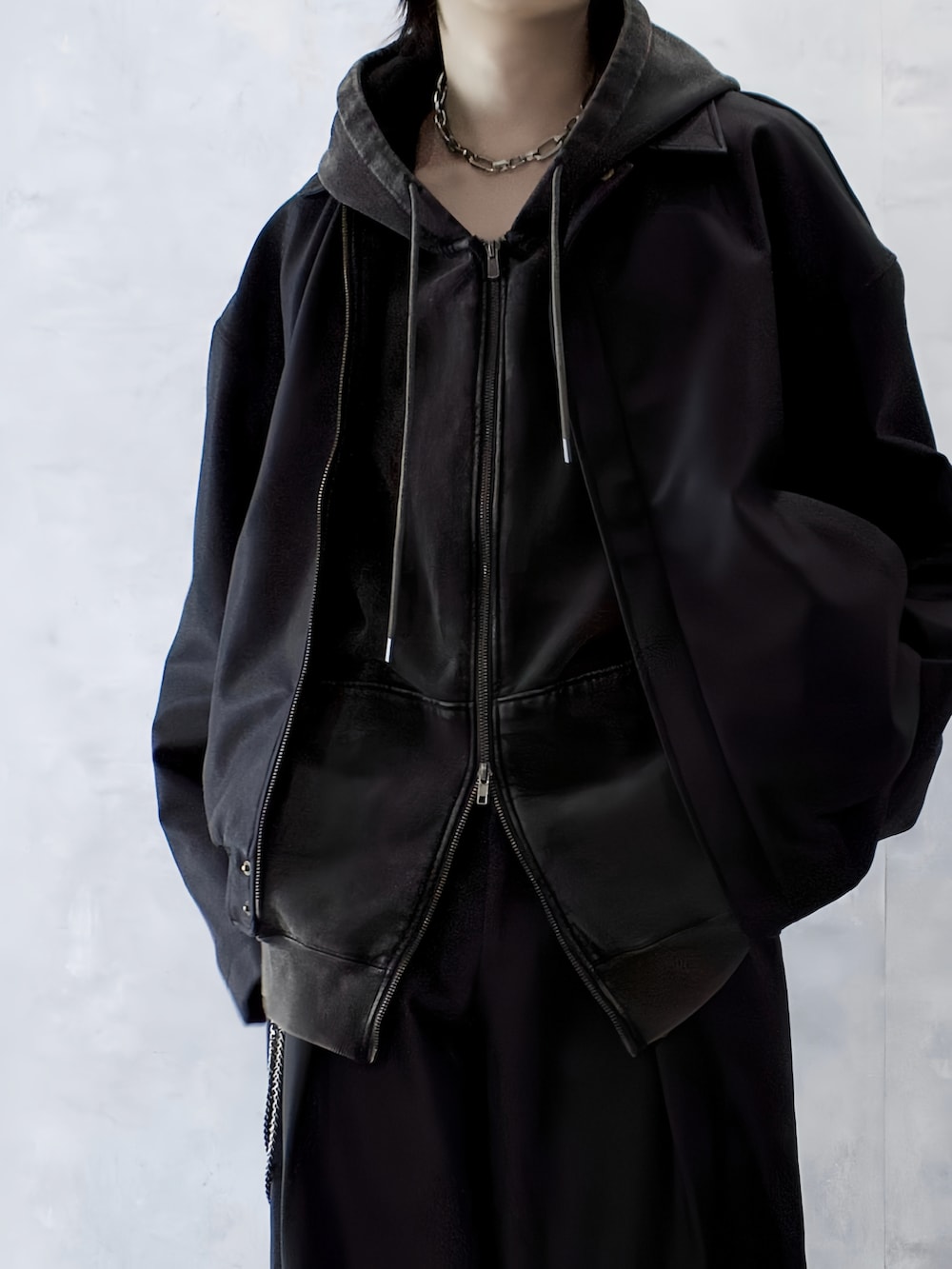 ブラウン系のパーカー、ブラック系のブーツ、ブラック系のブルゾンを着用したメンズの秋コーディネートの3枚目の写真