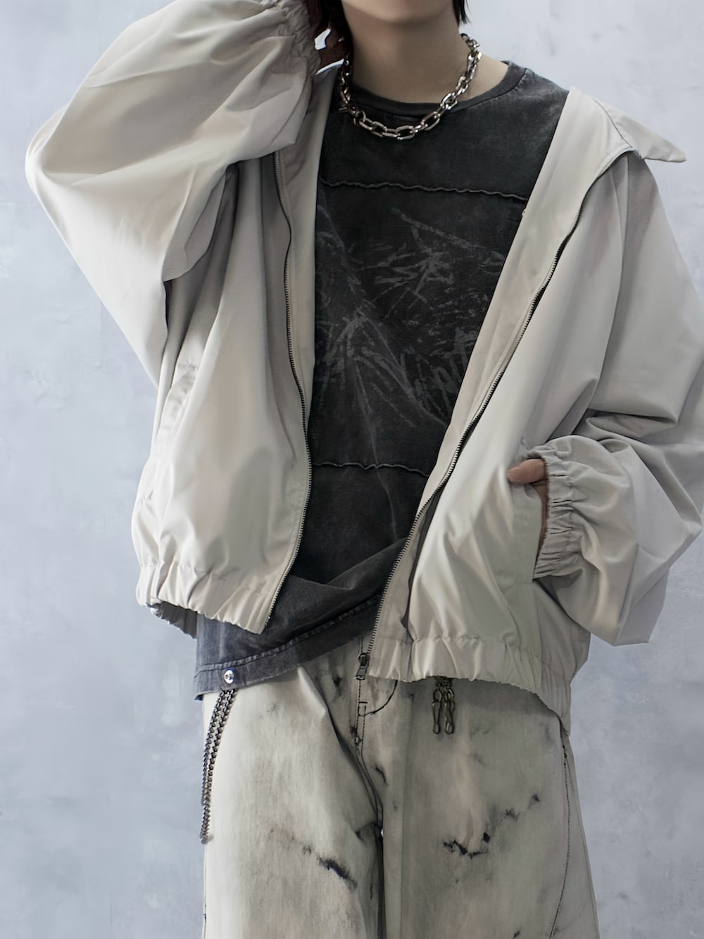 グレー系のデニムパンツ、ブラック系のTシャツ/カットソー、ホワイト系のブルゾンを着用したメンズの秋コーディネートの3枚目の写真