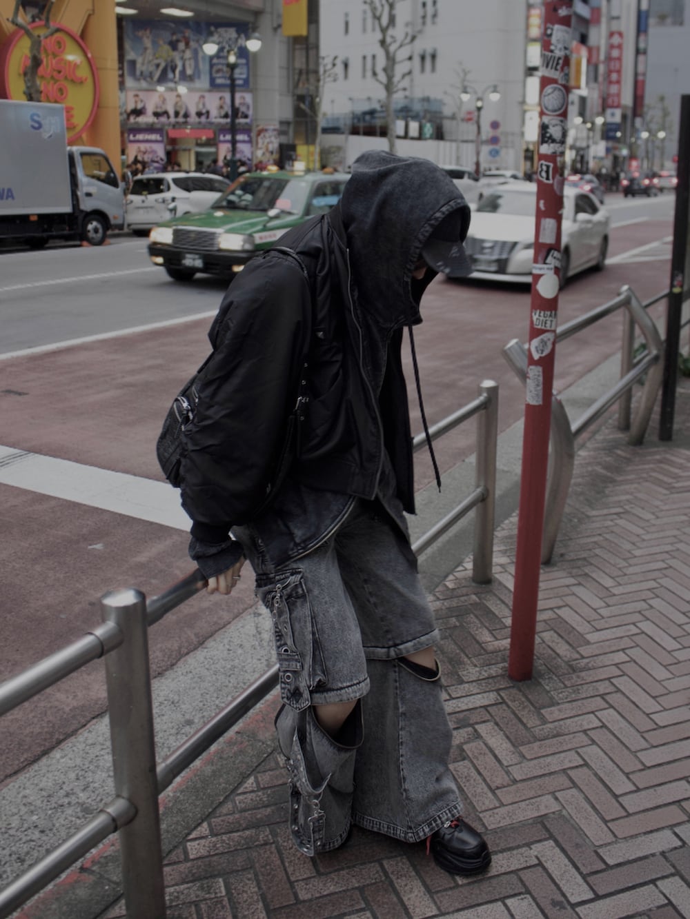 グレー系のデニムパンツ、ブラック系のスニーカー、ブラック系のMA-1を着用したメンズの冬コーディネートの2枚目の写真