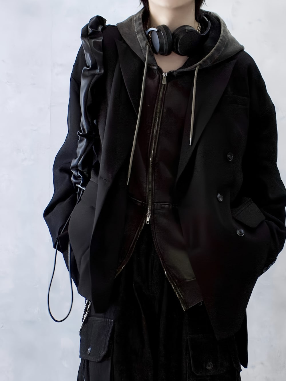 ブラック系のテーラードジャケット、ブラウン系のパーカー、ブラック系のカーゴパンツを着用したメンズの秋コーディネートの3枚目の写真