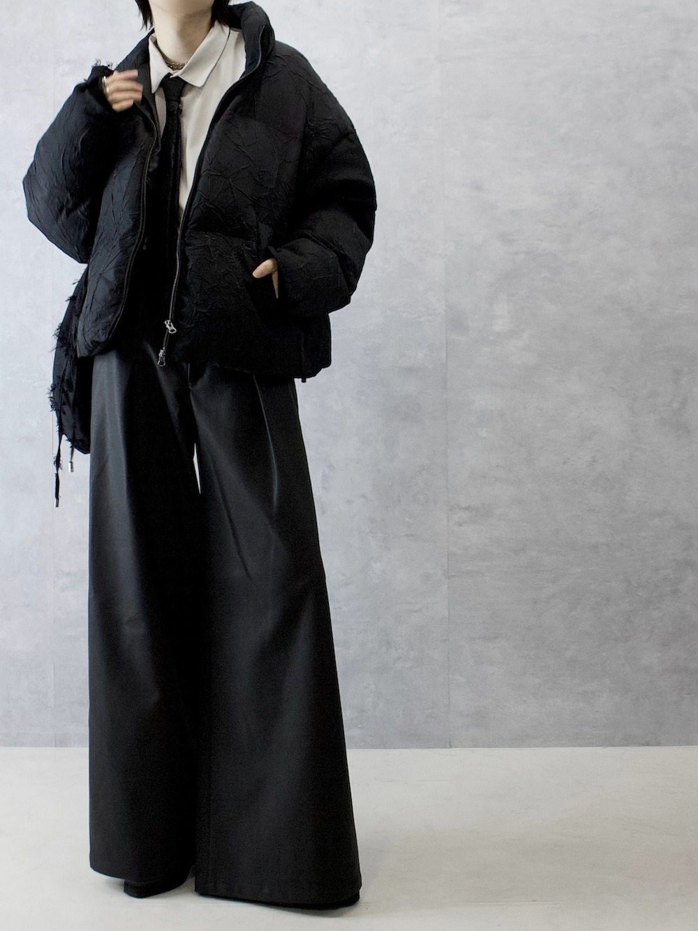 ブラック系のその他パンツ、ブラック系のダウンジャケット/コート、ベージュ系のシャツ/ブラウスを着用したメンズの冬コーディネートの4枚目の写真