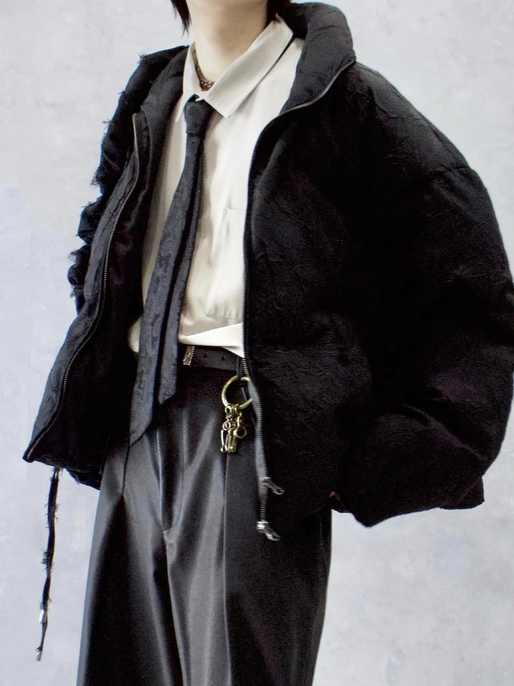 ブラック系のその他パンツ、ブラック系のダウンジャケット/コート、ベージュ系のシャツ/ブラウスを着用したメンズの冬コーディネートの3枚目の写真