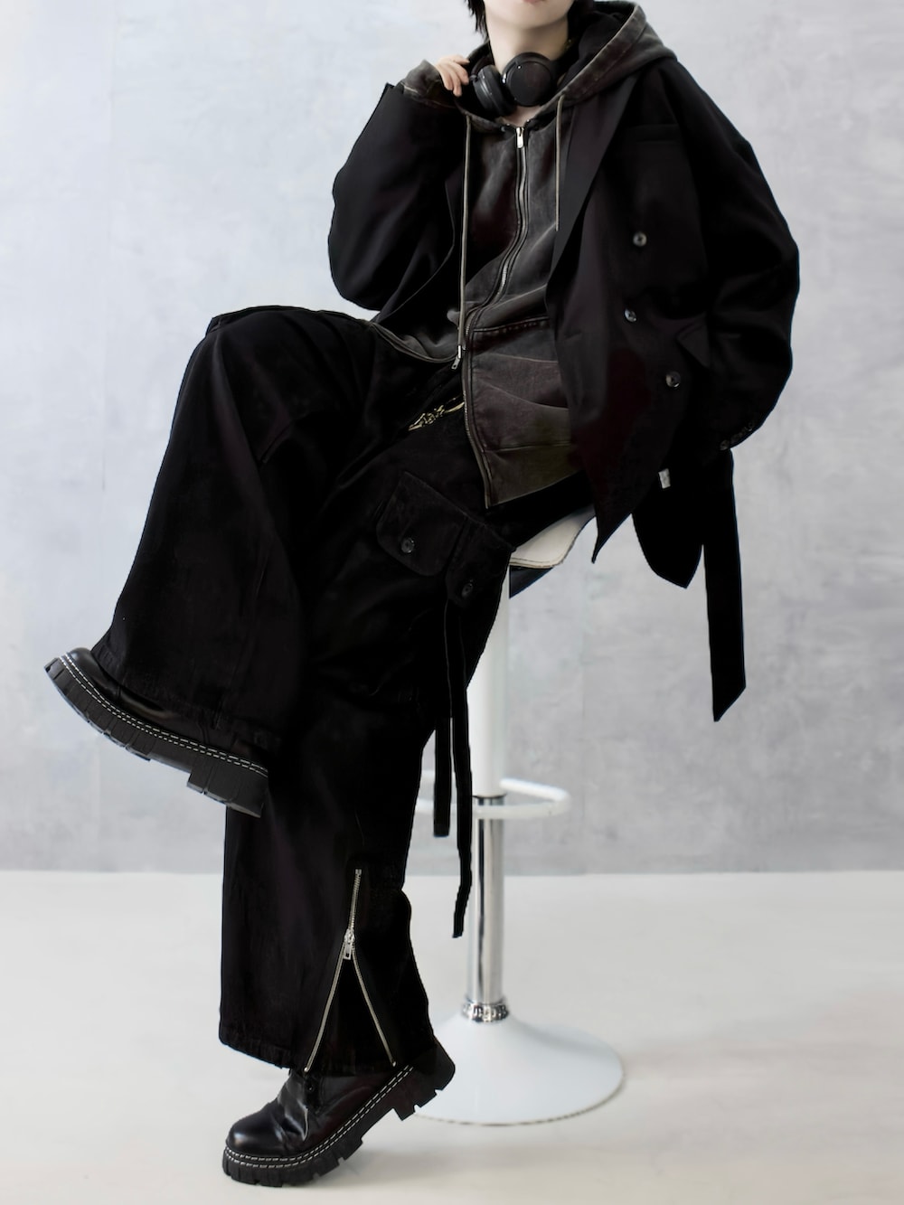 ブラック系のテーラードジャケット、ブラウン系のパーカー、ブラック系のカーゴパンツを着用したメンズの秋コーディネートの2枚目の写真