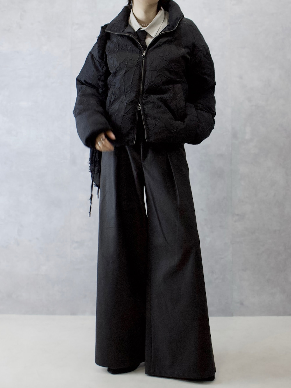 ブラック系のその他パンツ、ブラック系のダウンジャケット/コート、ベージュ系のシャツ/ブラウスを着用したメンズの冬コーディネートの5枚目の写真