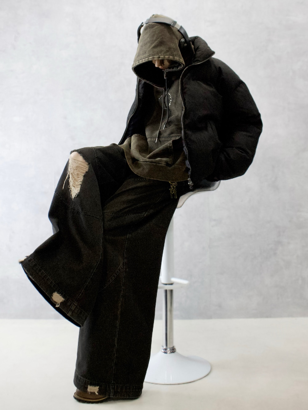 ブラック系のダウンジャケット/コート、ブラック系のパーカー、ブラック系のデニムパンツを着用したメンズの冬コーディネートの2枚目の写真