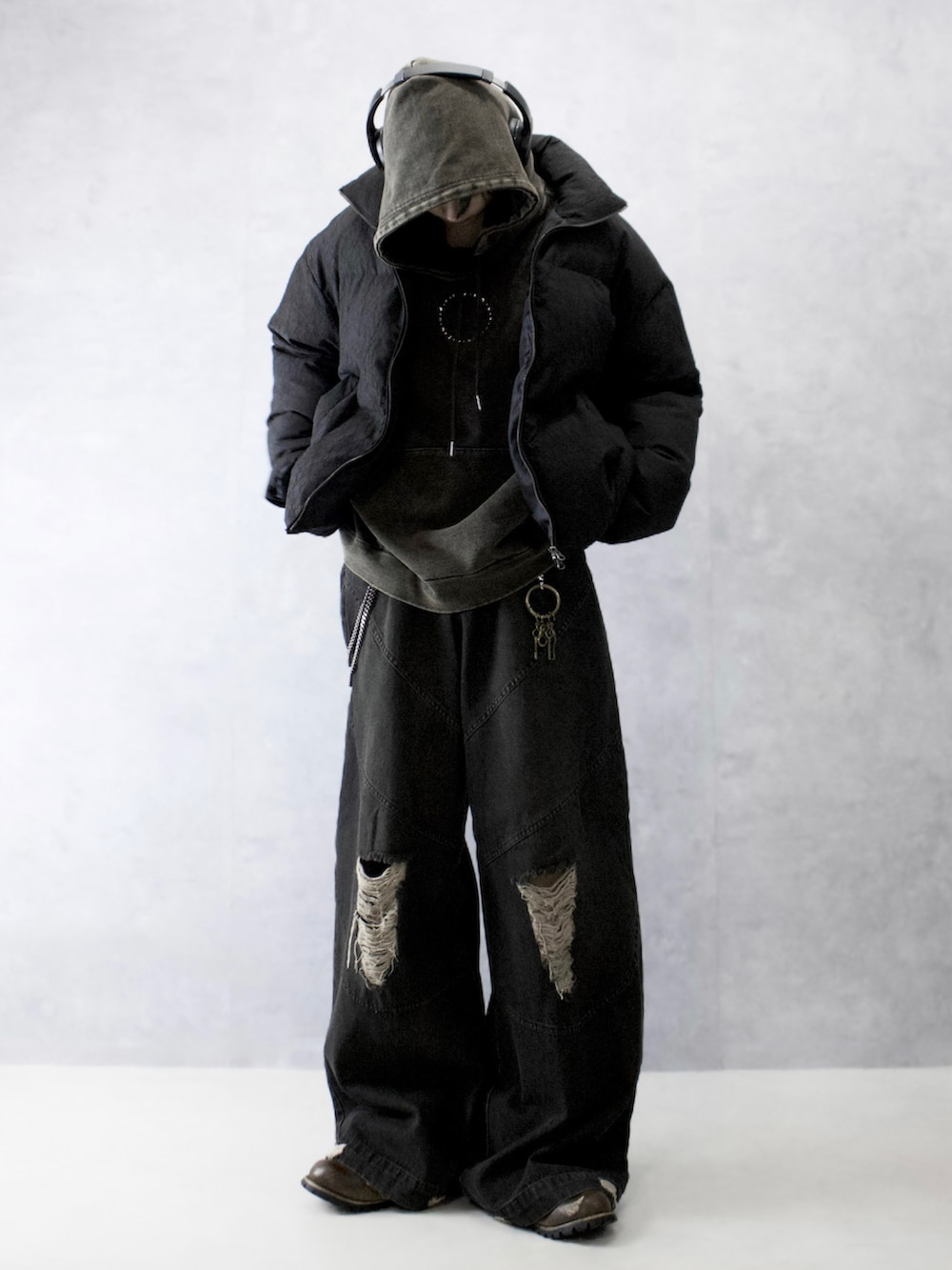 ブラック系のダウンジャケット/コート、ブラック系のパーカー、ブラック系のデニムパンツを着用したメンズの冬コーディネートの5枚目の写真