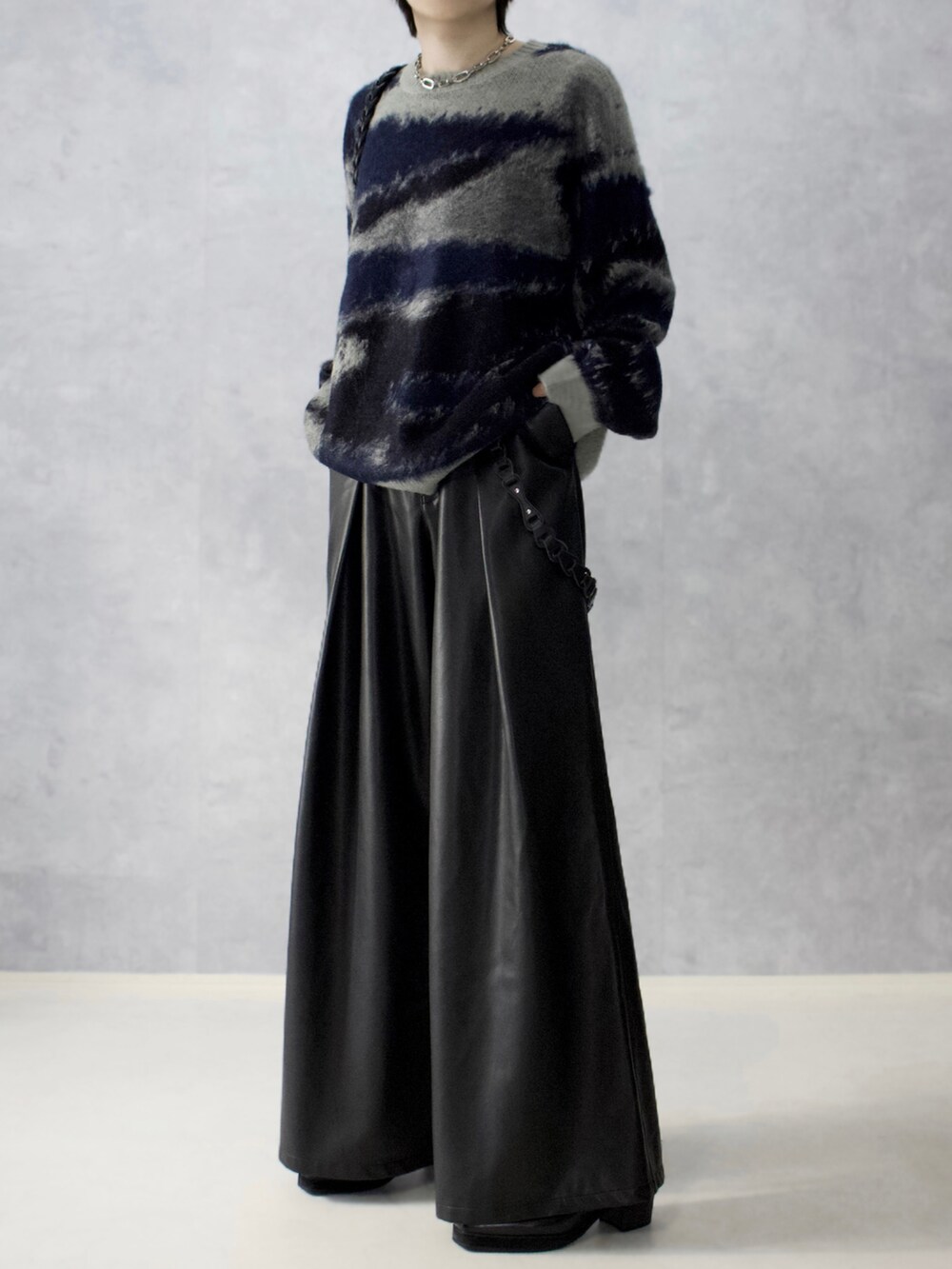 ブラック系のパンツ、ブルー系のニット/セーター、ブラック系のショルダーバッグを着用したメンズの秋コーディネートの5枚目の写真