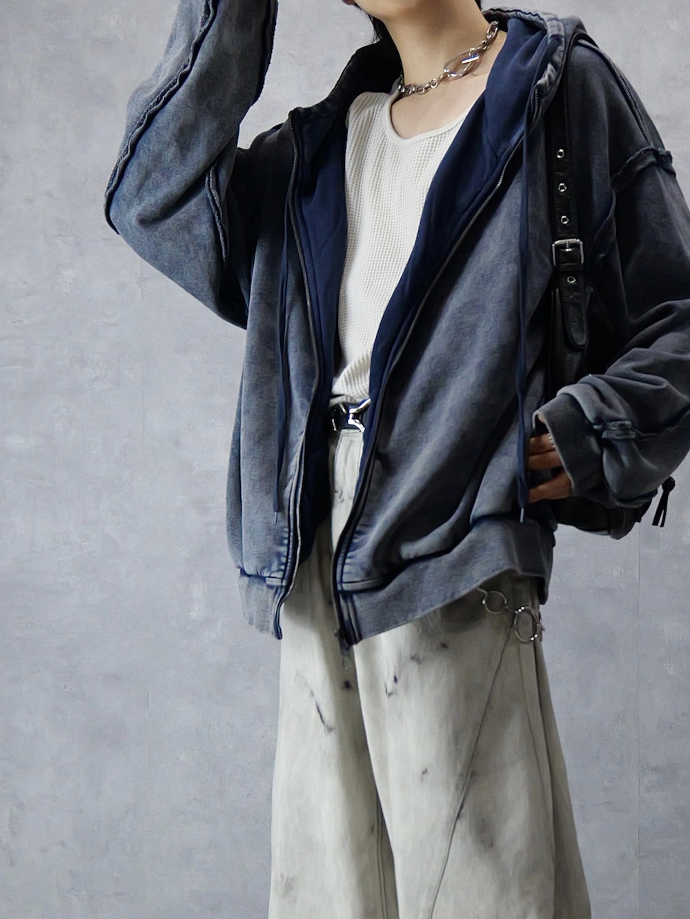 グレー系のデニムパンツ、ホワイト系のタンクトップ、ブラック系のショルダーバッグを着用したメンズの冬コーディネートの3枚目の写真